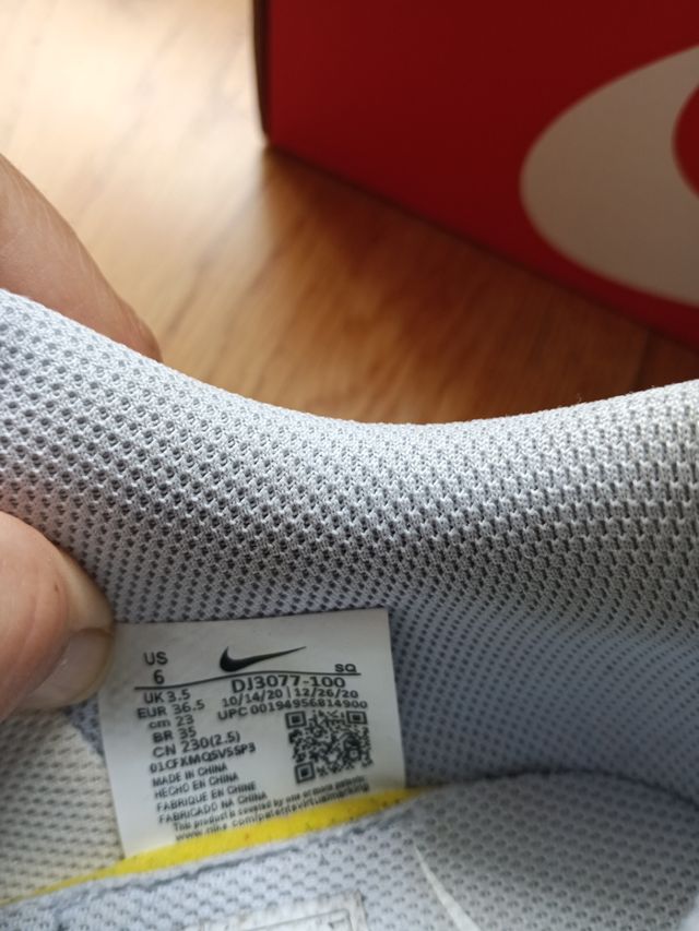 Zapatillas Nike altas azul-blanco y logo en beige.