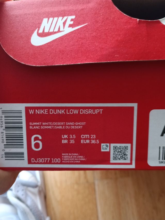 Zapatillas Nike altas azul-blanco y logo en beige.