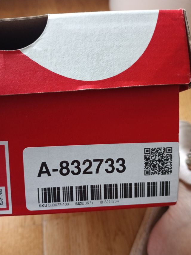 Zapatillas Nike altas azul-blanco y logo en beige.