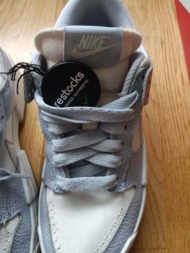 Zapatillas Nike altas azul-blanco y logo en beige.