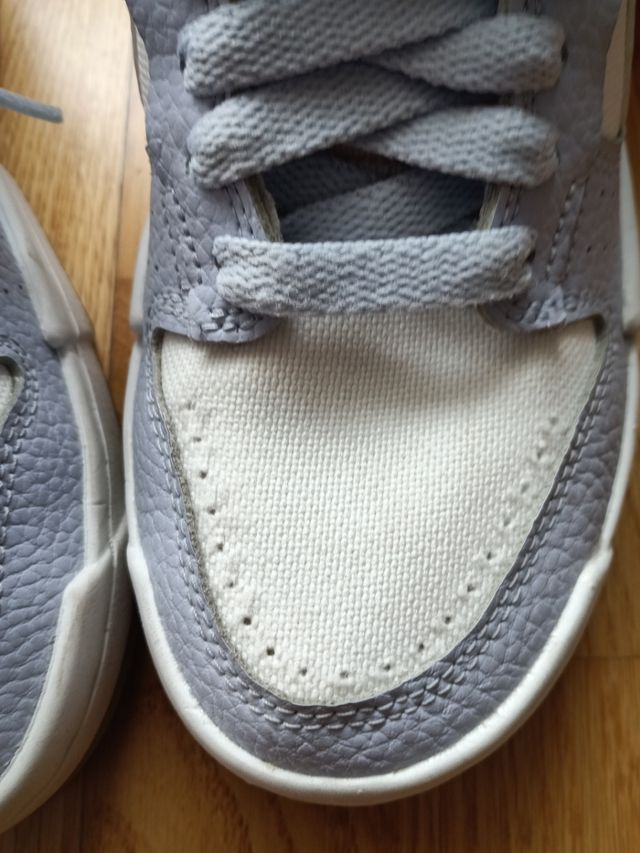 Zapatillas Nike altas azul-blanco y logo en beige.