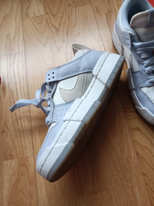 Zapatillas Nike altas azul-blanco y logo en beige.