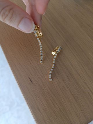 Pendientes de pinza dorados con brillantes.