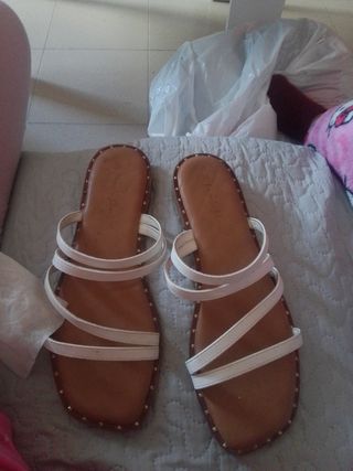 Sandalias planas blancas y marrones