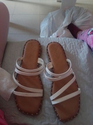 Sandalias planas blancas y marrones