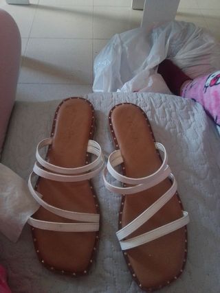 Sandalias planas blancas y marrones