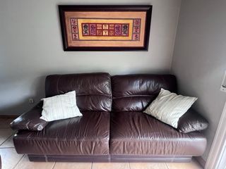 Dos juegos de sofas de 2 plazas de piel marrón. 
