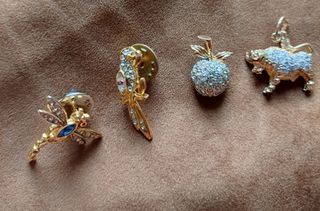 Broches dorados con pedrería y 2 colgantes.

