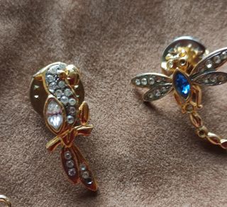 Broches dorados con pedrería y 2 colgantes.

