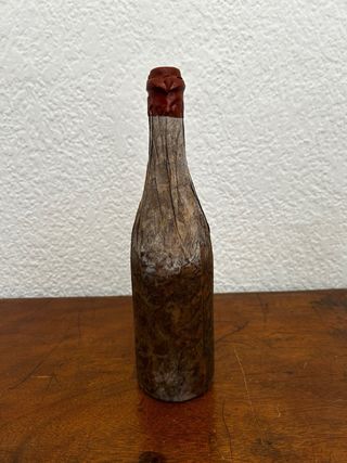 Botella antigua envuelta en hojas/tela