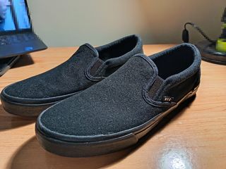 Zapatillas negras tipo Vans.
