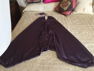 Mono de raso morado. Atado al cuello con tirantes.
