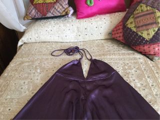 Mono de raso morado. Atado al cuello con tirantes.
