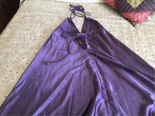Mono de raso morado. Atado al cuello con tirantes.