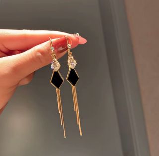 Aretes colgantes dorados con detalles negros