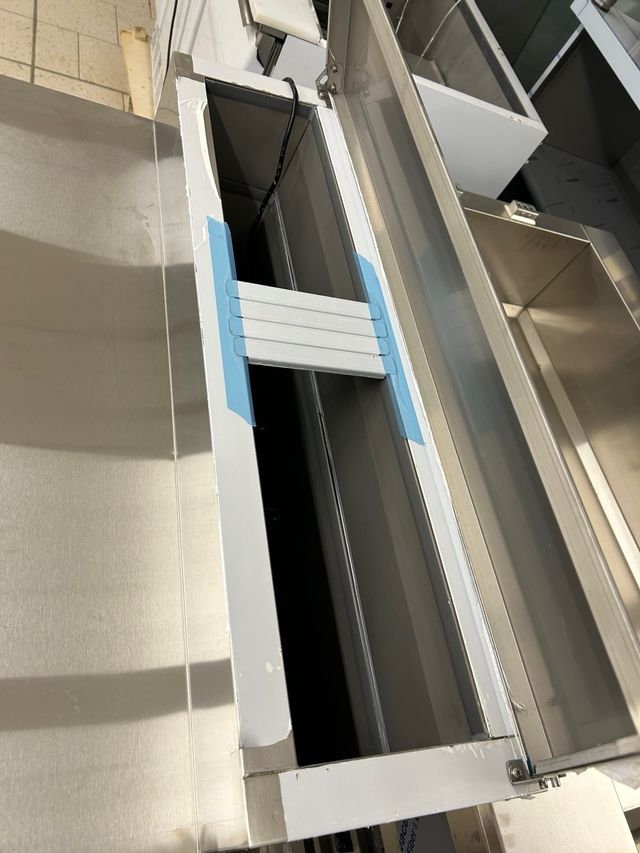 Bajo mostrador acero inoxidable con ingredientes.