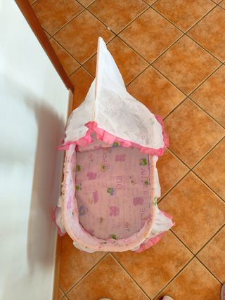 Cuna moisés rosa bebé de juguete. 