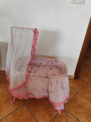 Cuna moisés rosa bebé de juguete. 