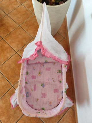 Cuna moisés rosa bebé de juguete. 