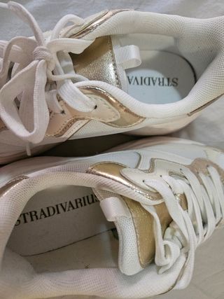 Zapatillas deportivas blancas y doradas