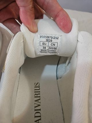 Zapatillas deportivas blancas y doradas