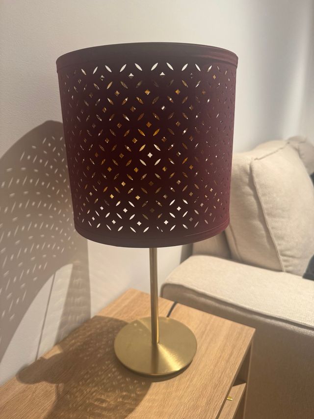 Lámpara Ikea dorada y burdeos, da una luz cálida 