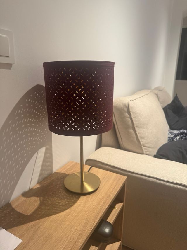 Lámpara Ikea dorada y burdeos, da una luz cálida 