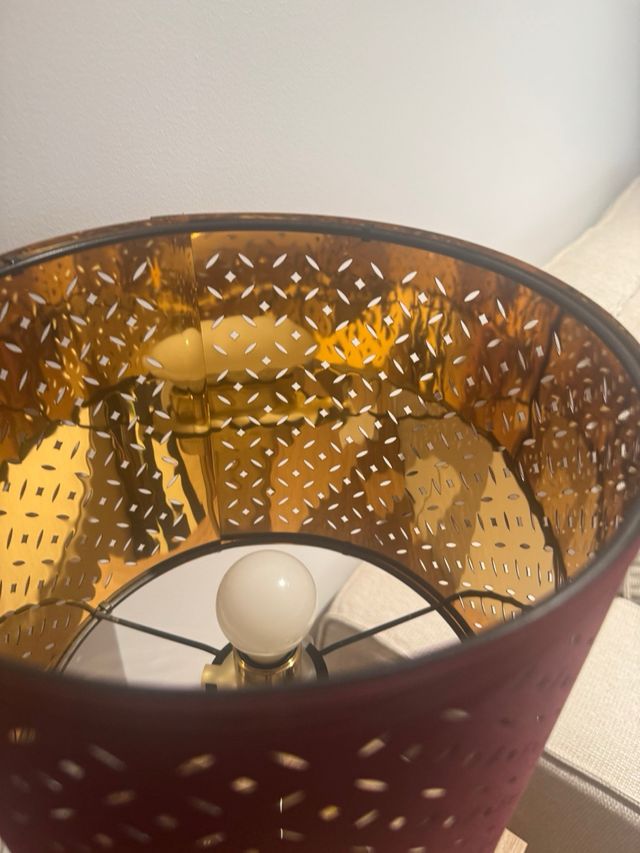 Lámpara Ikea dorada y burdeos, da una luz cálida 