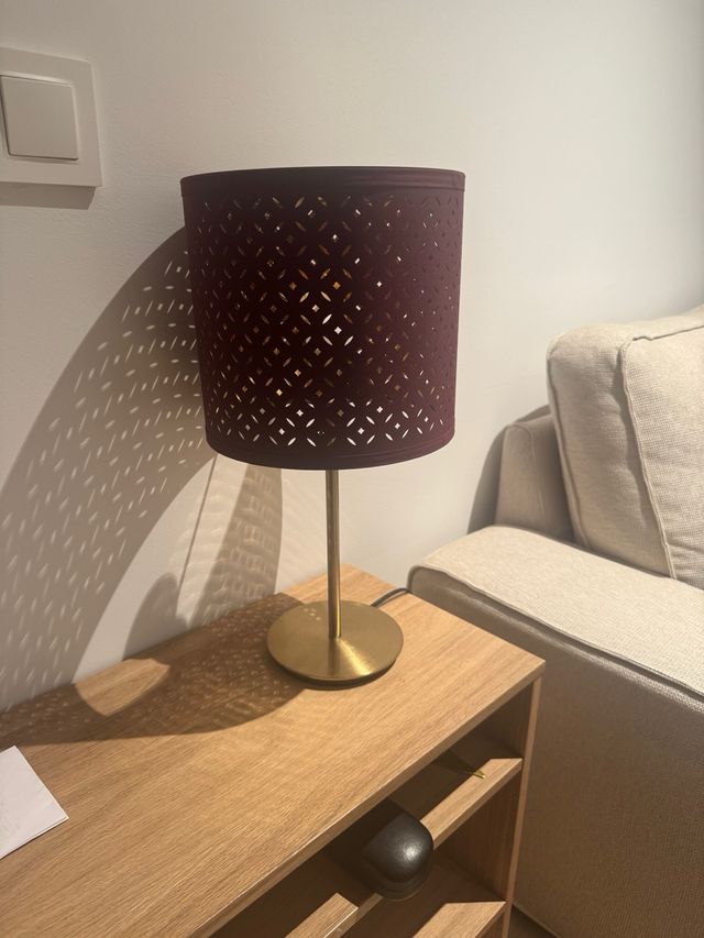 Lámpara Ikea dorada y burdeos, da una luz cálida 