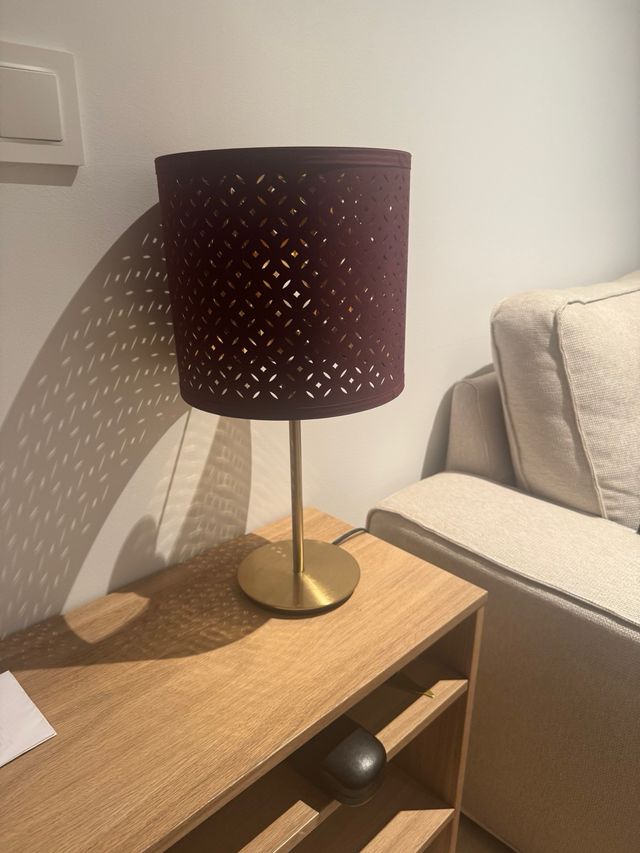 Lámpara Ikea dorada y burdeos, da una luz cálida 