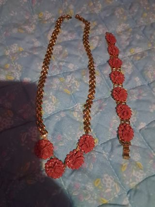 Collar y pulsera dorados con flores rojas