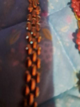 Collar y pulsera dorados con flores rojas