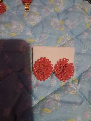 Collar y pulsera dorados con flores rojas