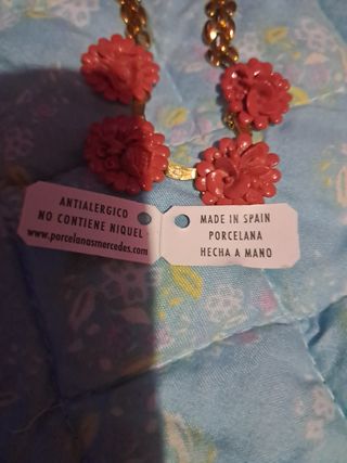 Collar y pulsera dorados con flores rojas