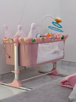 Cuna bebé rosa con móvil