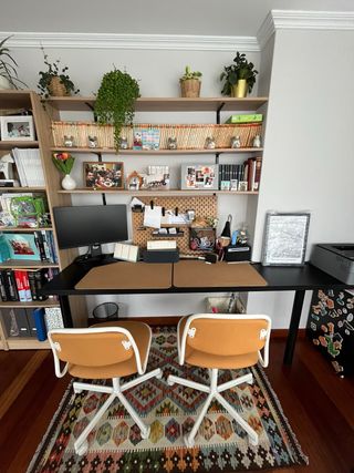 Escritorio negro con 2 sillas naranjas