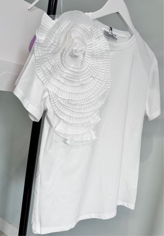 Camiseta blanca con una flor voluminosa