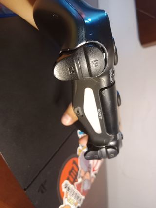 (Playstation 4) com un mando y un video juego 
