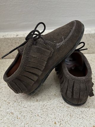 Zapatos ante niño con flecos