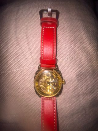 Reloj dorado con correa roja