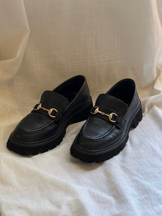 Mocasines negros con hebilla dorada