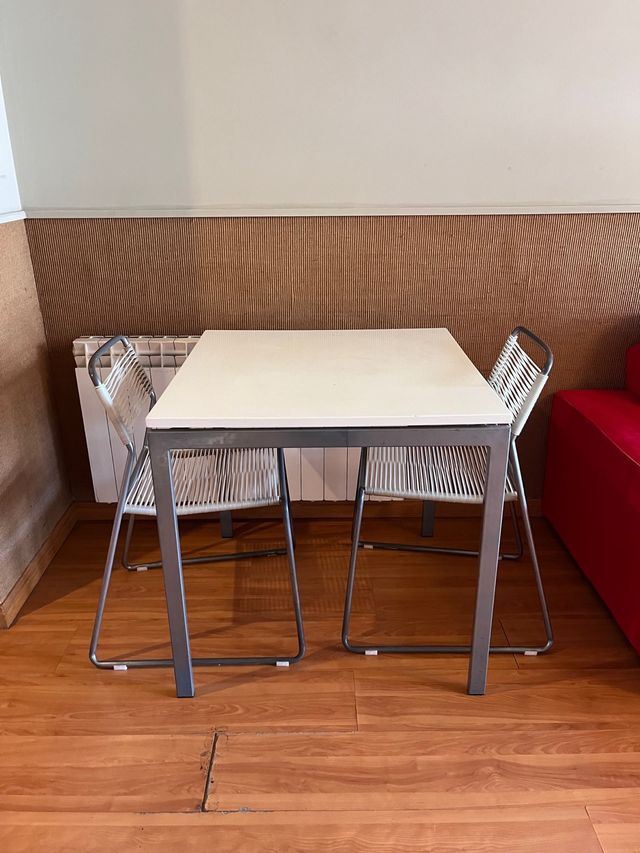 Tavolo in metallo grigio e piano in legno bianco.