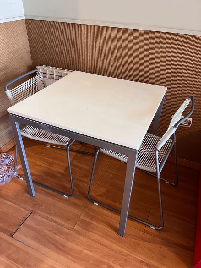 Tavolo in metallo grigio e piano in legno bianco.