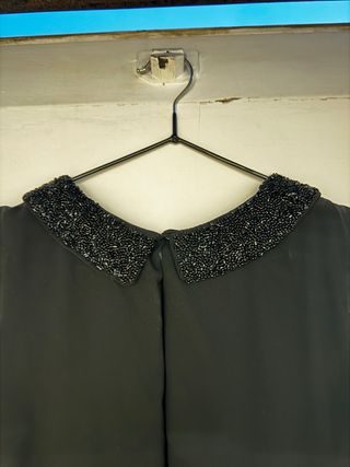 Blusa negra con cuello adornado
