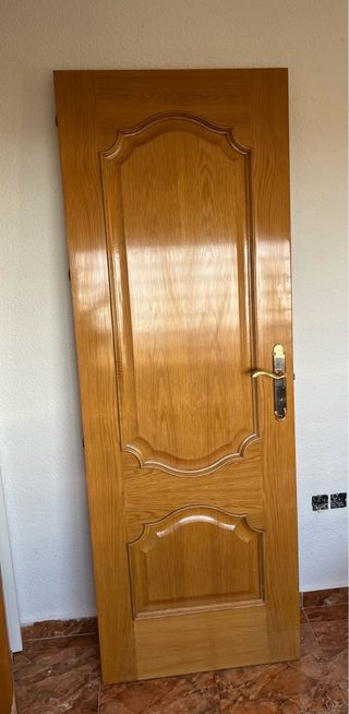 Puerta de roble con manilla dorada
