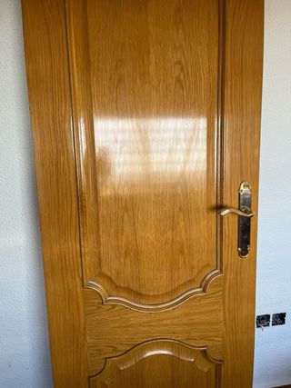 Puerta de roble con manilla dorada