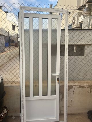 Puerta metálica blanca con cristal