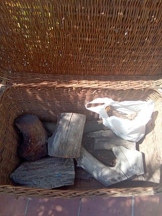 Leña, piñas y gran baúl de mimbre.