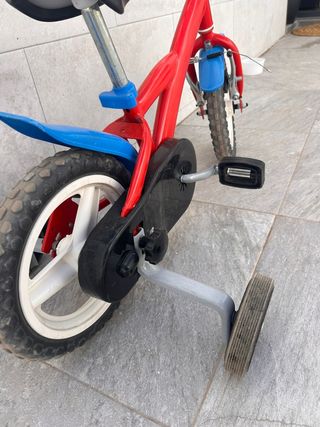 Bicicleta infantil roja con ruedines