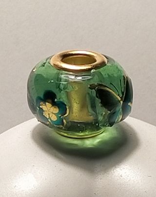 Charm artesanal verde con detalles dorados